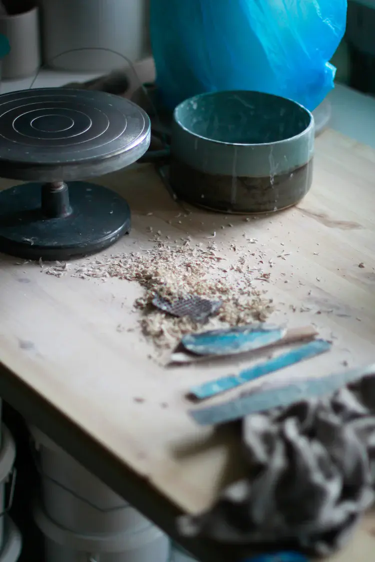 Textured slab-built ceramic vessel on canvas surface